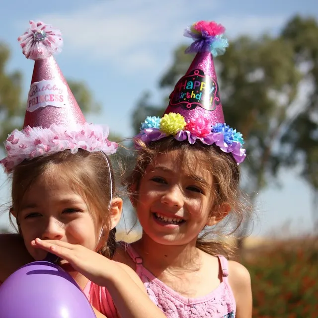 Dos niñas con gorros de fiesta